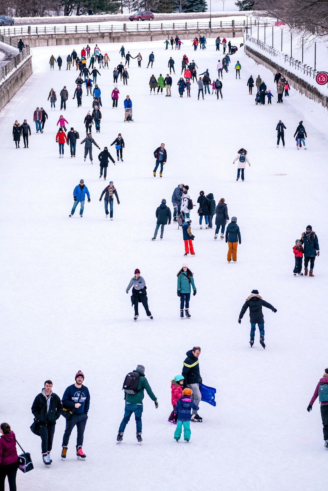 Skaters gliding across a public outdoor ice rink in winter