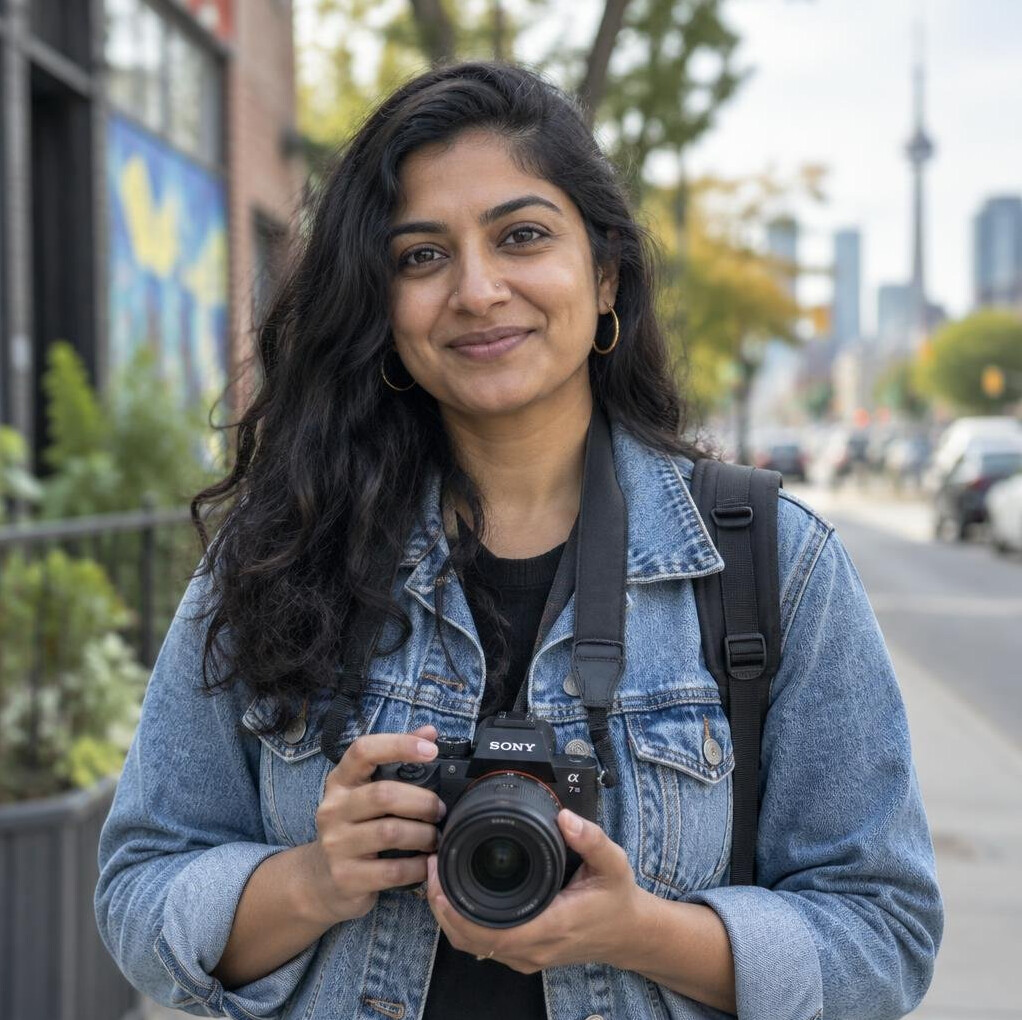 Portrait of a South Asian Canadian documentary photographer holding a camera