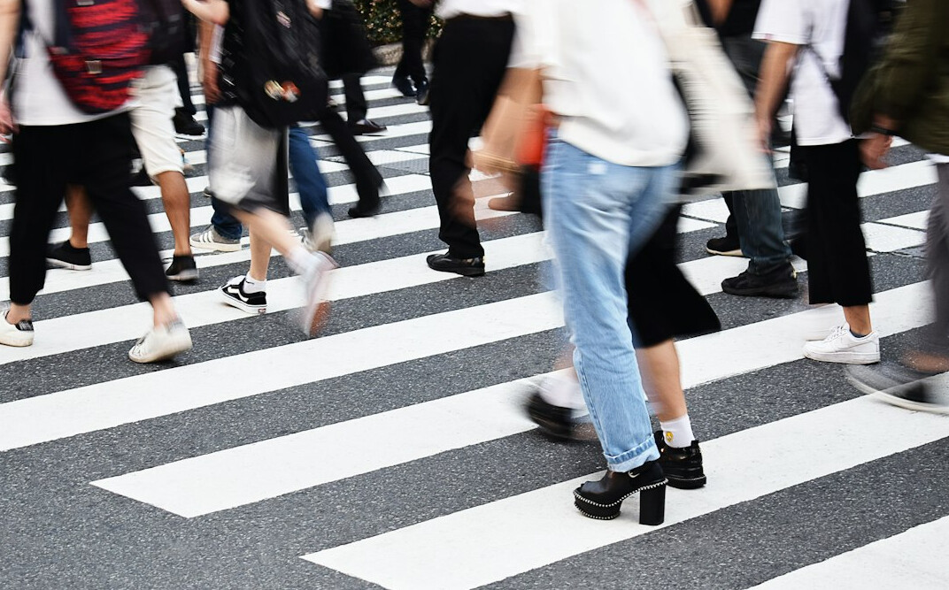 A busy pedestrian crosswalk in a Canadian downtown intersection